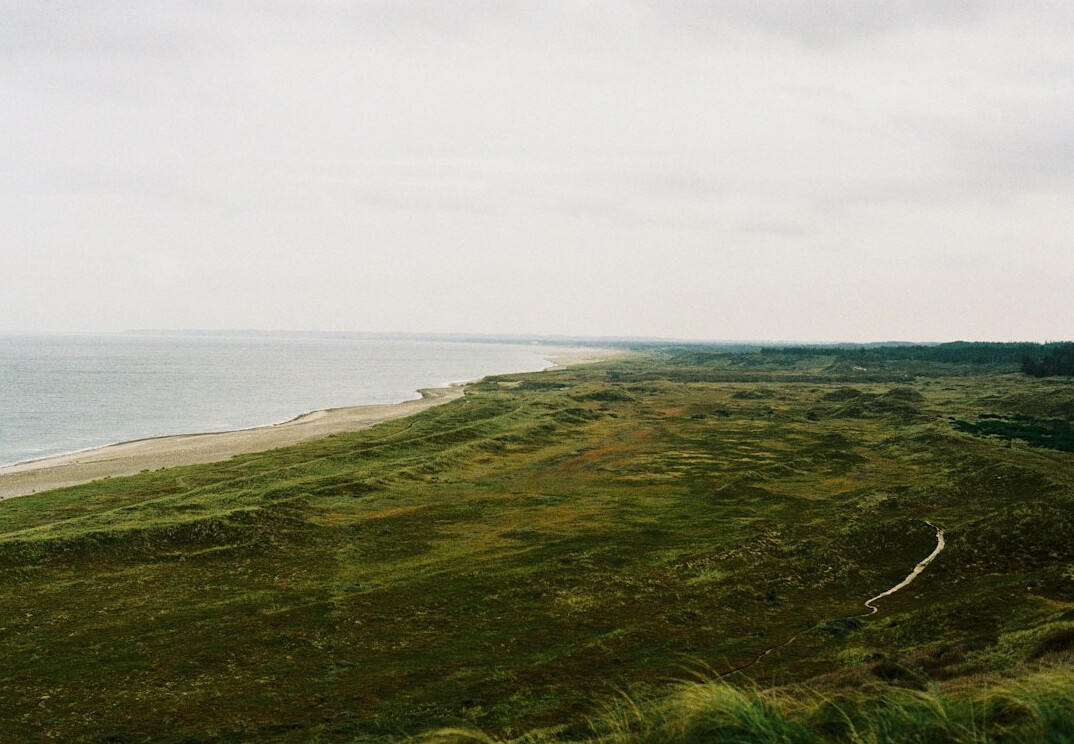 Danish countryside with a small red cottage and open fields