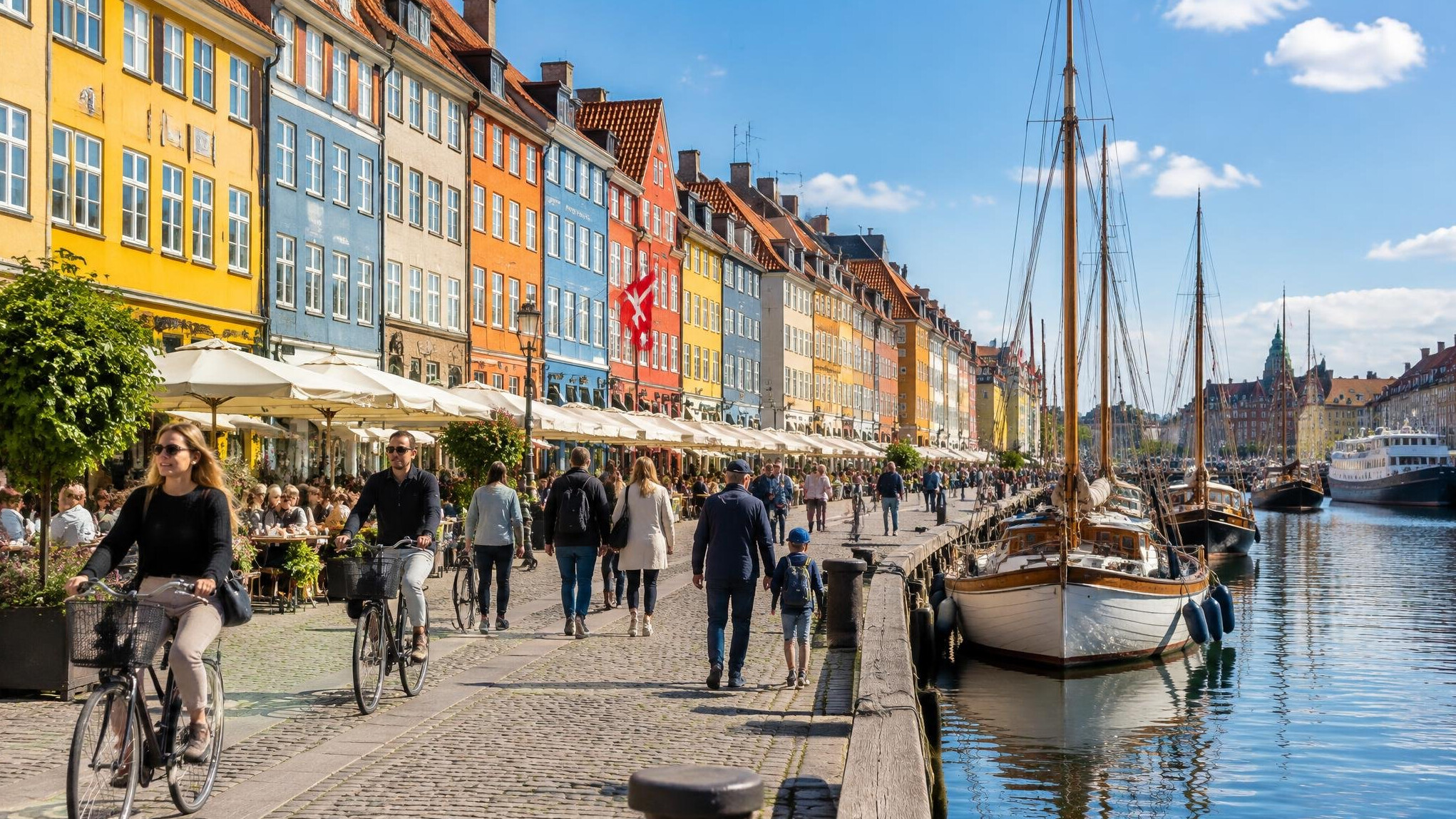 Colorful harbor houses in Copenhagen with people walking by